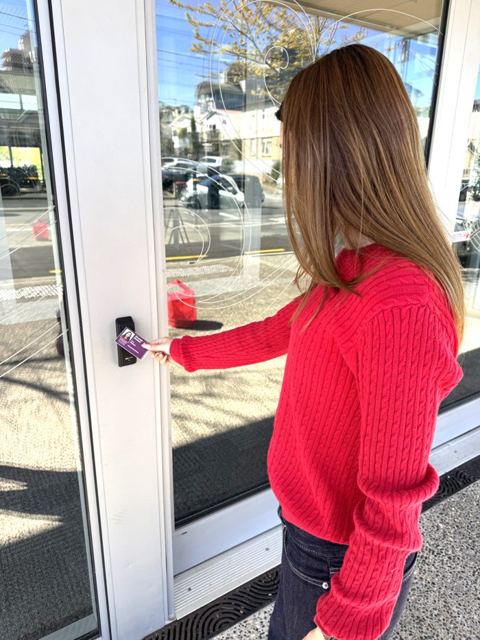 A student taps a purple ID card printed by CardOffice on a door reader